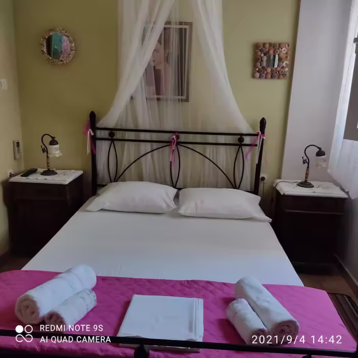 Δωμάτιο με διπλό φούξια κρεβάτι και κουνουπιέρα